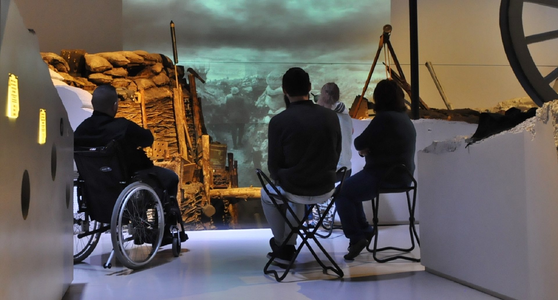 Visiteurs en situation de handicap moteur près de la reconstitution de tranchées au Musée de la Gande Guerre